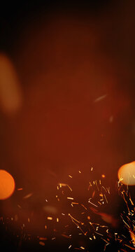  Fire embers particles over black background. Fire sparks background. Abstract dark glitter fire particles lights. vertical banner.