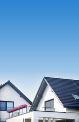 The dark-blue roofes of a new modern residential houses. Ceramic top roofes. Tiled covering of building. Blu sky background. Copy space. © MarKord