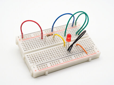 Symmetrical breadboard circuit setup with looping colorful jumper wires and red indicator.