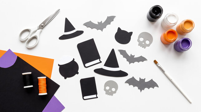 Halloween craft flat lay paper pumpkins, ghosts, bats, paints, scissors
