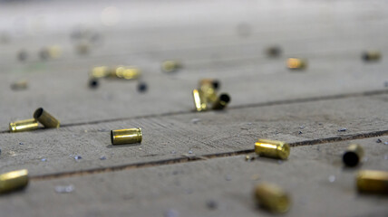Scattered spent shell casings in an indoor shooting range, selective focus. © Сергей Иванкин