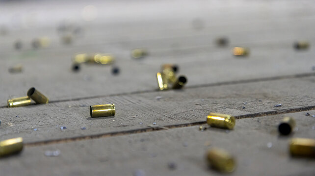 Scattered spent shell casings in an indoor shooting range, selective focus.