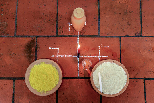 Food and a candle placed on the ground as an offering to Exu in Umbanda.