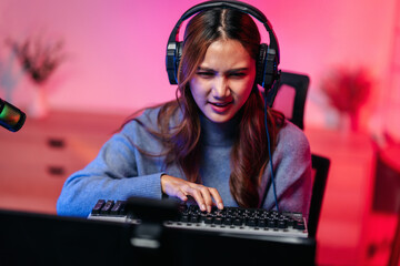 Woman gamer intently plays keyboard games streaming esports comp © Freedomz