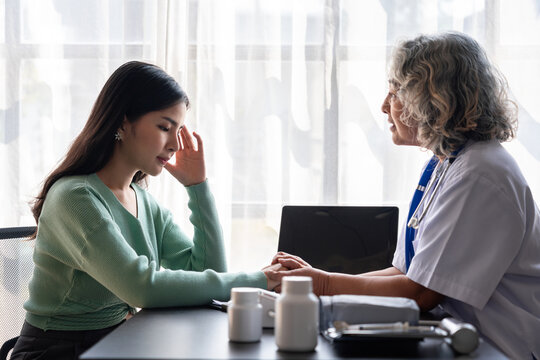 Doctor Consulting with Patient Asian Women Experiencing Headache