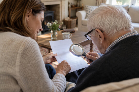 Family Member Assisting Visually Impaired Relative with Mail and Documents