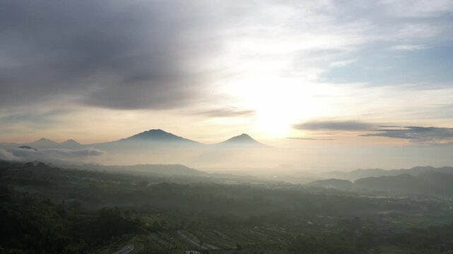 Aerial View of Misty Mountain Peaks at Sunrise in Tropical Valley