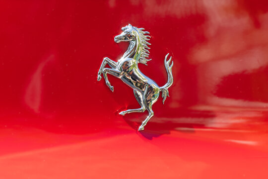 Ljubljana, Slovenia - 4 August 2026: Ferrari emblem with prancing horse displayed on a bright red sports car at an auto event.