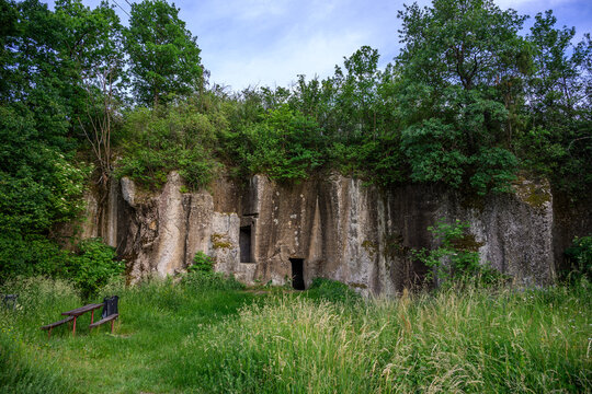 Rock-cut walls and cellar doorways of the Stramploch quarry hidden in green woods, Krupina, Slovakia