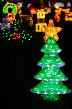 A glowing Christmas tree figure with a star on top on a field of glowing figures