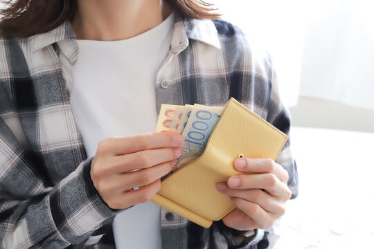 財布から現金を取り出す女性