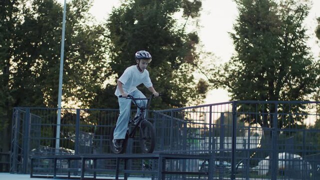 10 Year Old Boy Performing Bunny Hop Jump on BMX Bicycle in Skate Park
