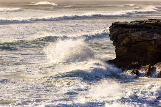 massive waves crashing into rock formations, Walker Bay Nature Reserve, South Africa at sunset