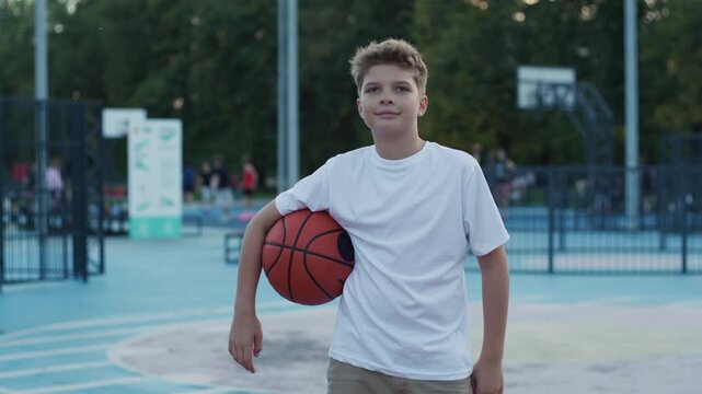 Portrait of 10 Year Old Boy Holding Basketball Ball Outdoors