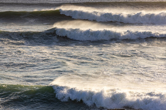 massive waves crashing into rock formations, Walker Bay Nature Reserve, South Africa at sunset