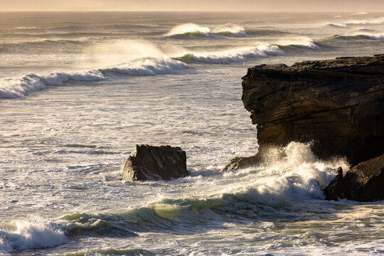 massive waves crashing into rock formations, Walker Bay Nature Reserve, South Africa at sunset