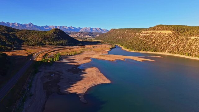 Aerial morning sunrise illuminates calm waters and foothills around Ridgway Reservoir and State Park in Colorado