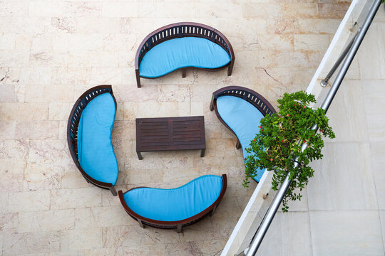 Four blue sofas arranged around central coffee table, top view.