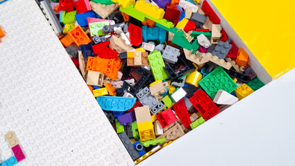 Obraz premium Huge pile of colorful unsorted lego plastic building blocks and toy bricks inside storage tray with white baseplate in play area on September 22, 2026 in Bangkok, Thailand.
