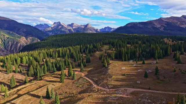 Panoramic aerial sunset illuminates rugged Needles peaks viewed from Molas Overlook along the Million Dollar Highway in Colorado