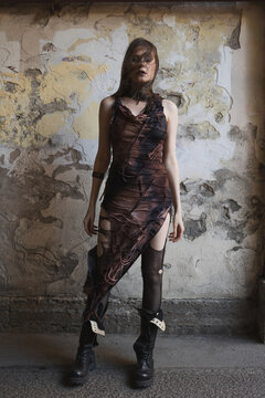 Melancholic woman with closed eyes and windblown hair, loneliness in post-apocalyptic ruins