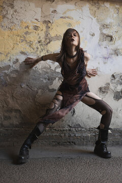 Woman throwing head back with eyes closed, emotional release, dystopian grunge fashion pose