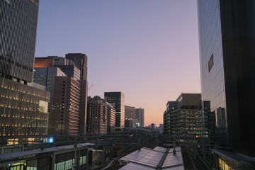 Obraz premium Osaka city skyline at dusk with modern buildings and railway tracks, Japan