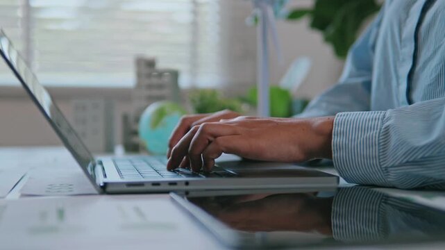 Businesswoman reviewing ESG reports and green business financial charts with a laptop and documents. ESG concept Environmental, Social, and Governance, eco-friendly green building, sustainable