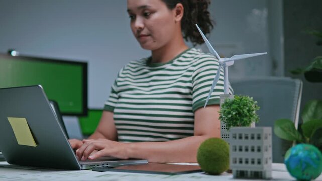 Businesswoman reviewing ESG reports and green business financial charts with a laptop and documents. ESG concept Environmental, Social, and Governance, eco-friendly green building, sustainable