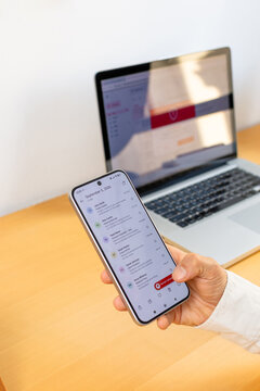 Hand holding smartphone while reviewing email and reporting suspicious message