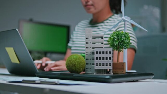 A female engineer analyzing and modeling a modern building, focusing on eco-friendly architecture, sustainable green business with renewable energy, future goals, and environmental sustainability.