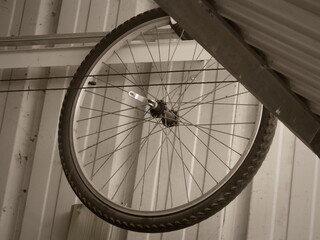 A bicycle wheel hanging inside a metal shed becomes a striking geometric composition. The spokes create a hypnotic pattern, while the industrial setting adds raw authenticity.  © catf