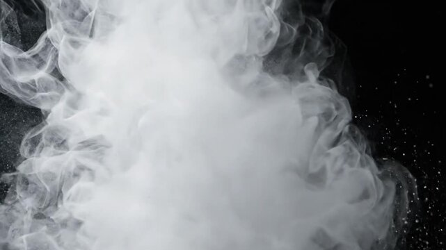 White dust powder falls and spreads on a black background in a slow motion display