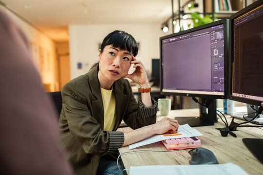 Woman listening during office meeting at computer