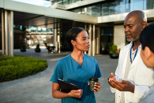 Nurse and doctor discussing case outside hospital