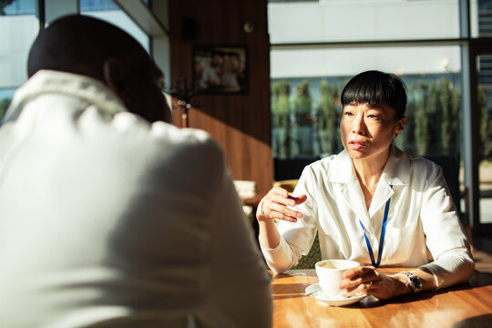 Woman talking with colleague over coffee in cafe