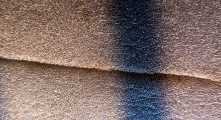 Abstract texture of expanded polyethylene foam padding with layered sheets in dark gray tones. © Z.Graphikos