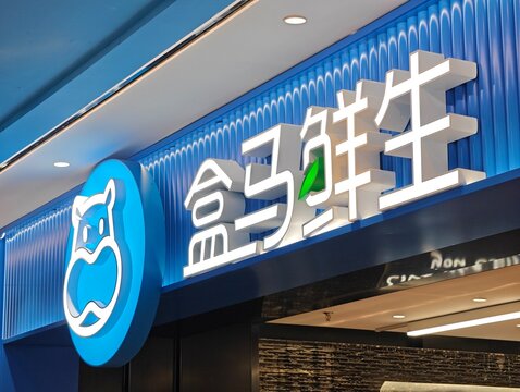Shanghai,China-Dec.31st 2025: close-up illuminated store sign and hippo logo of a Freshippo (Hema Market) supermarket