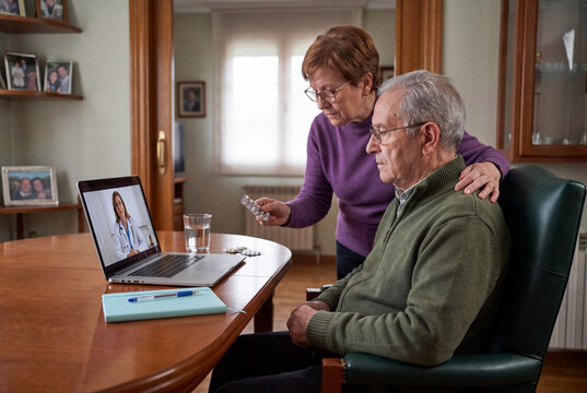 Senior Couple Having Online Telemedicine Video Consultation with Doctor on Laptop at Home