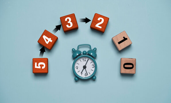 Alarm clock with numbered blocks and arrows represents countdown, deadline, time management and urgency with illustrating steps toward zero for business planning, schedule and productivity concepts.