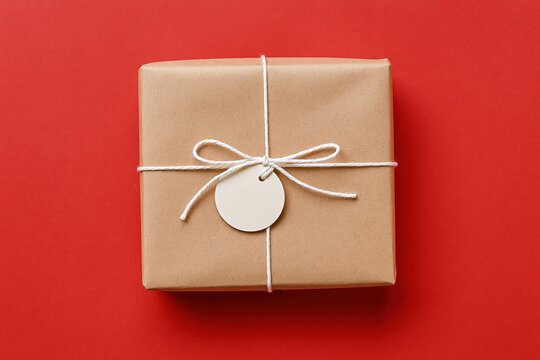 The Gift Box Wrapped in Kraft Paper with White String and Tag