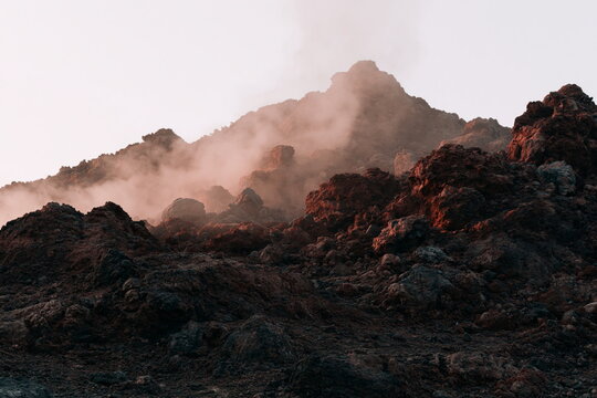 Majestic Volcanic Crater Rim Bathed in Golden Dawn Light with Serene Mist
