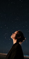 Fototapeta premium Woman silhouette looking up at a starry night sky for contemplative background and peaceful poster design