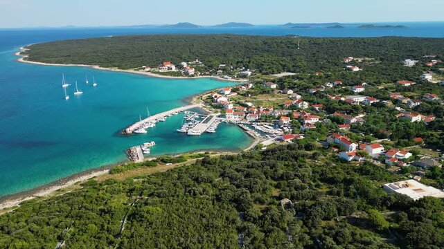 Aerial drone panorama of the eastern part of Silba Island, Croatia, surrounded by the crystal-clear Adriatic Sea. The picturesque coastal village, turquoise shoreline and Mediterranean vegetation