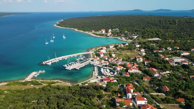 Aerial drone panorama of the eastern part of Silba Island, Croatia, surrounded by the crystal-clear Adriatic Sea. The picturesque coastal village, turquoise shoreline and Mediterranean vegetation