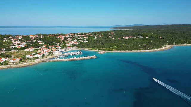 Aerial drone panorama of the eastern part of Silba Island, Croatia, surrounded by the crystal-clear Adriatic Sea. The picturesque coastal village, turquoise shoreline and Mediterranean vegetation