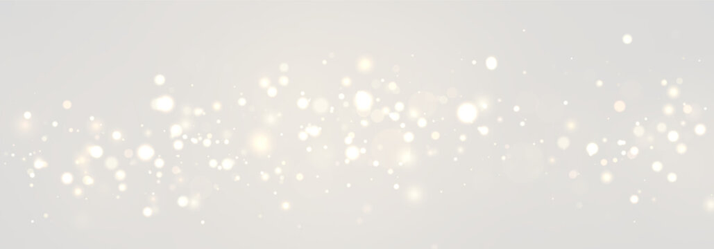 A scattering of soft golden bokeh lights fills the midsection of the dark background. The lights vary in size, brightness, and hue creating a warm glowing effect.