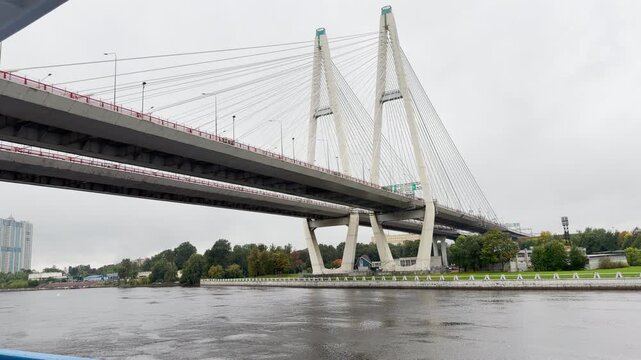 The grand bridge spans across the calm river. Travelers feel awe and wonder in this peaceful environment.