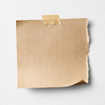 Blank torn paper note taped on white wall background.