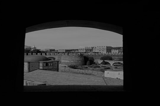 Vue sur une ancienne ville fortifi&eacute;e de G&eacute;orgie &agrave; travers une ouverture en pierre en noir et blanc